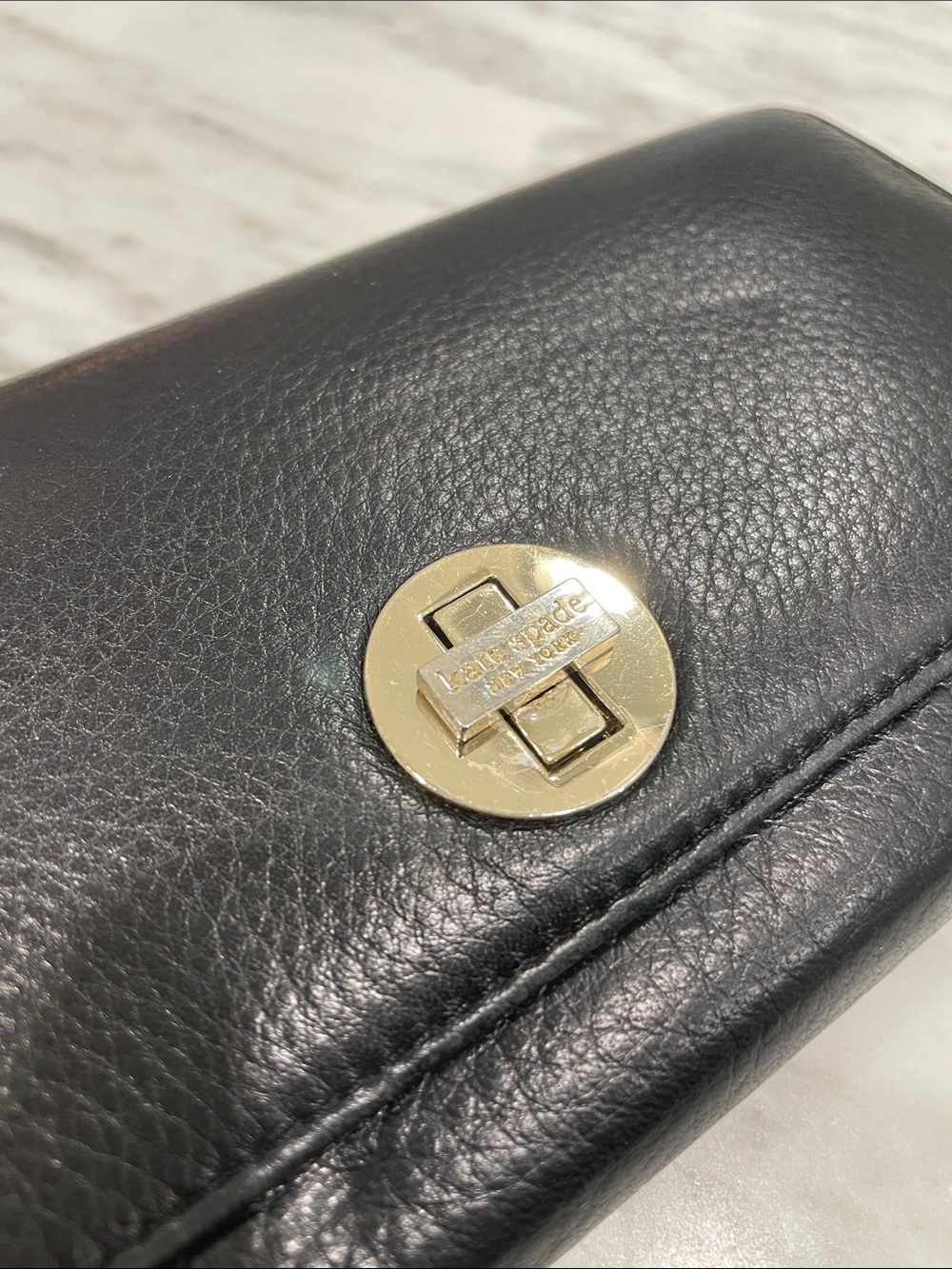 kate spade black leather wallet with gold circular turn-lock